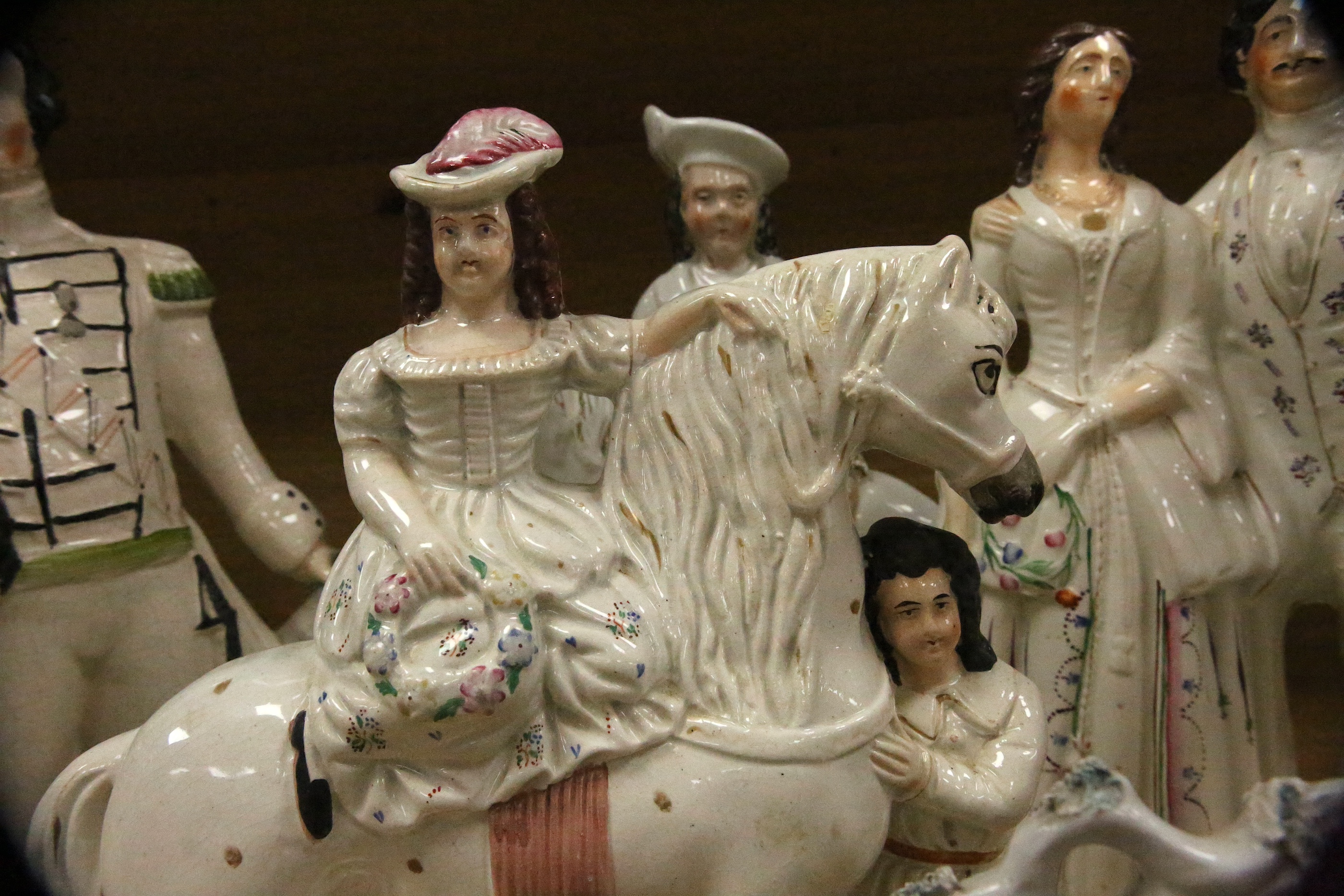 Staffordshire pottery: a bocage group, 25.5cm, 'Huntsman' 40.5cm, figure with child groom 40.5cm, figure of girl beside a column 30cm, George and Eliza Harris, 36cm, 'Dundas' beside a cannon, 40.5cm, gentleman and lady h